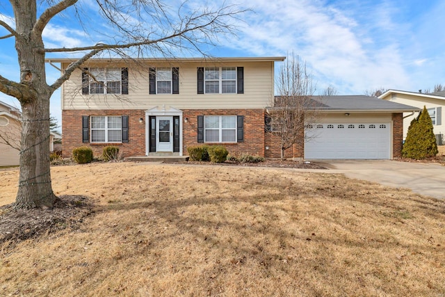 colonial home with a garage, concrete driveway, brick siding, and a front yard