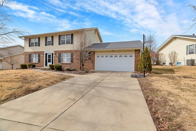 colonial home featuring a garage, concrete driveway, brick siding, and a front lawn