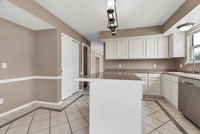 kitchen featuring a center island, decorative light fixtures, stainless steel dishwasher, white cabinetry, and a sink