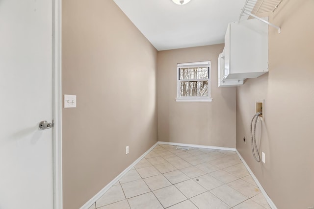 washroom with washer hookup, cabinet space, light tile patterned flooring, electric dryer hookup, and baseboards