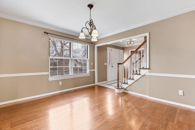 entrance foyer with stairway, baseboards, visible vents, and wood finished floors