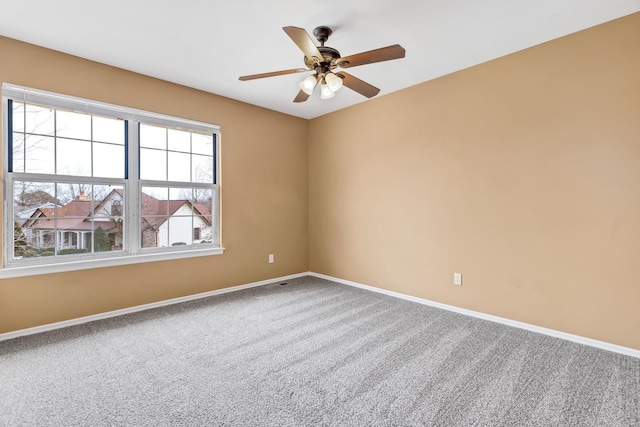 empty room featuring carpet floors, baseboards, and a ceiling fan