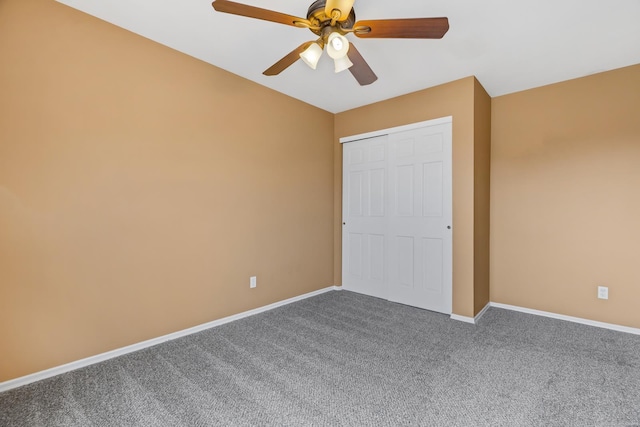 unfurnished bedroom featuring carpet, baseboards, ceiling fan, and a closet