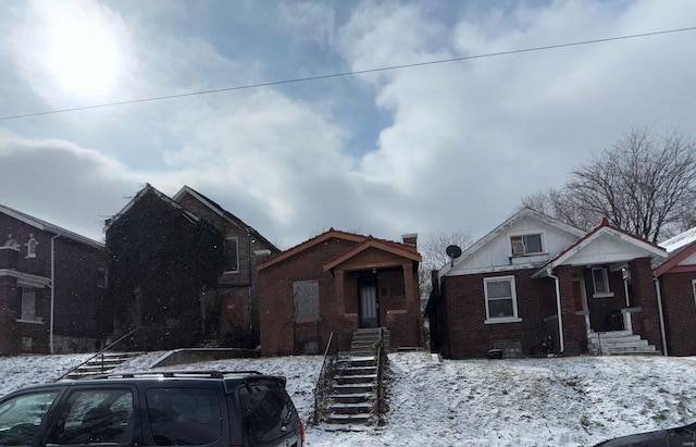 bungalow featuring brick siding