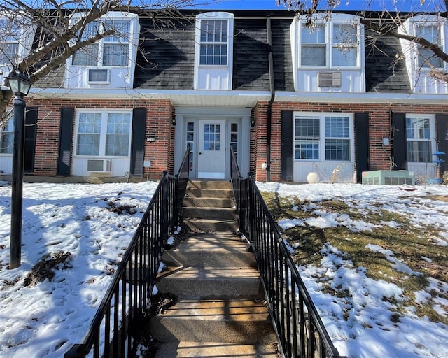 view of front of property featuring cooling unit and brick siding