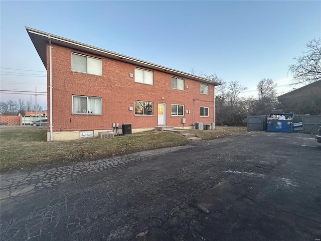 exterior space with central AC and brick siding