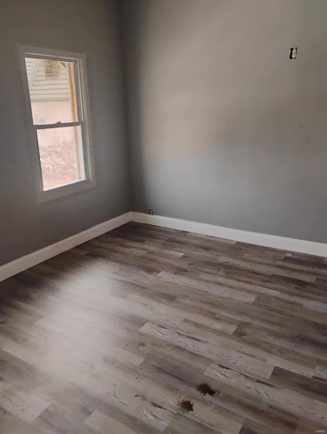 empty room with baseboards and dark wood-style flooring