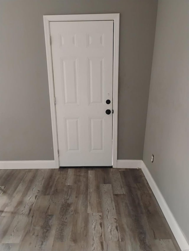 doorway with baseboards and wood finished floors