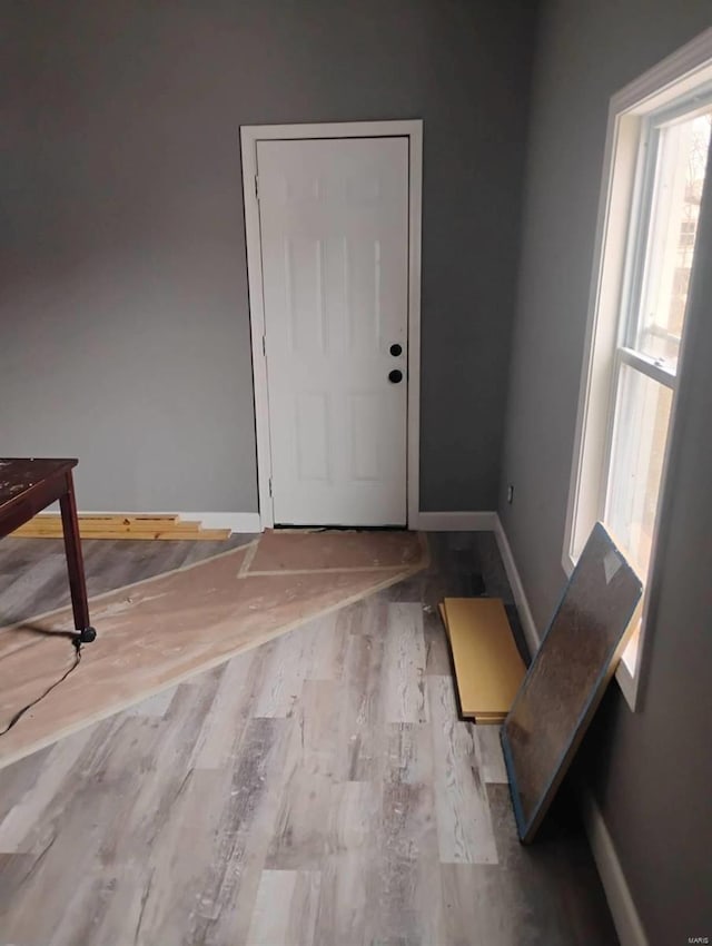 doorway to outside with wood finished floors and baseboards