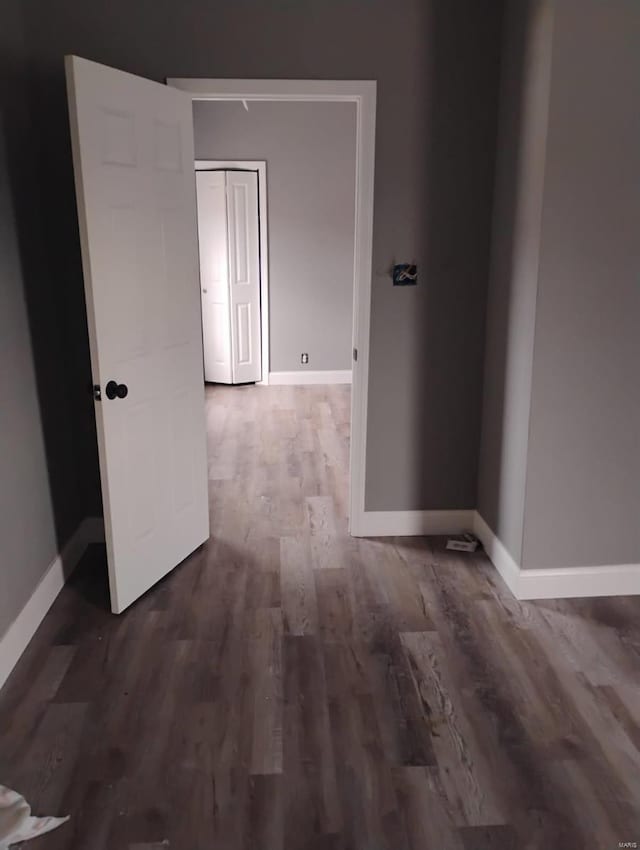 corridor with wood finished floors and baseboards