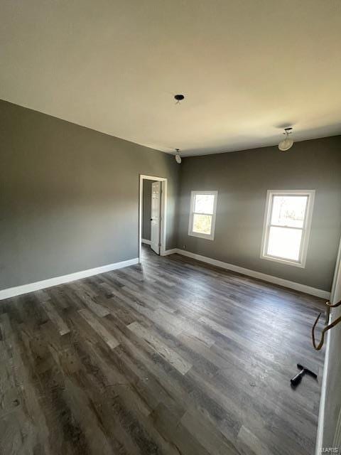 unfurnished room featuring dark wood-type flooring and baseboards