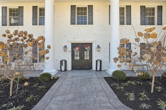 entrance to property featuring french doors and brick siding