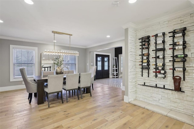 dining area featuring baseboards, ornamental molding, and hardwood / wood-style flooring