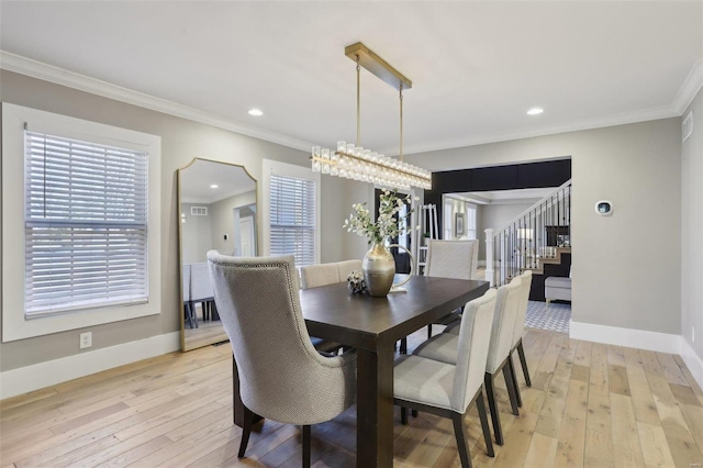 dining room featuring crown molding, stairway, baseboards, and light wood-type flooring