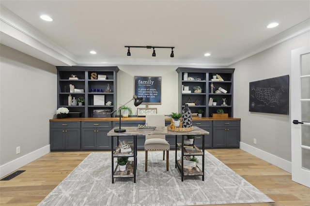 interior space featuring ornamental molding, baseboards, visible vents, and light wood-type flooring