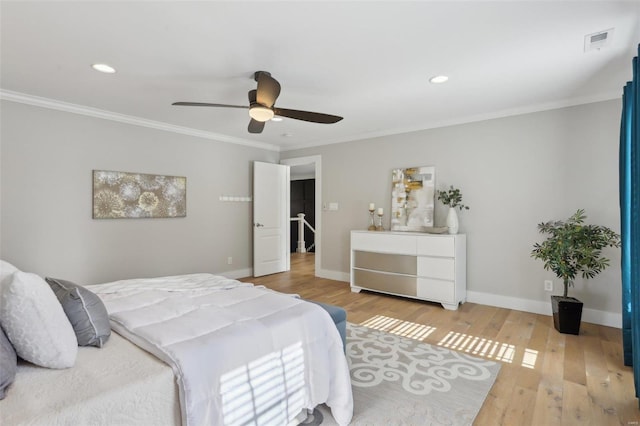 bedroom featuring wood finished floors, visible vents, baseboards, ceiling fan, and crown molding