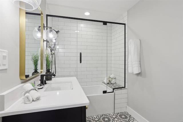 full bath featuring vanity, baseboards, combined bath / shower with glass door, and tile patterned flooring