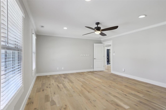 spare room with crown molding, light wood-style flooring, baseboards, and ceiling fan