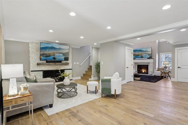 living area with recessed lighting, wood finished floors, a lit fireplace, and ornamental molding