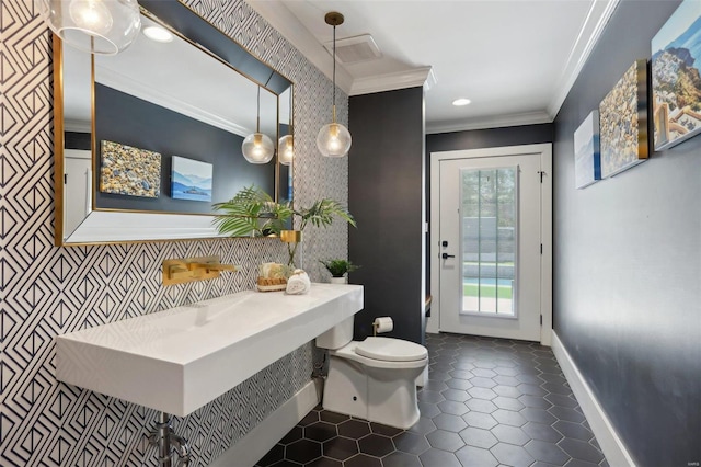 bathroom featuring baseboards, toilet, crown molding, and tile patterned flooring