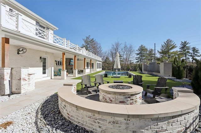 view of patio / terrace with a balcony and an outdoor fire pit