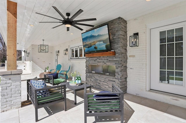 view of patio featuring ceiling fan and an outdoor living space with a fireplace