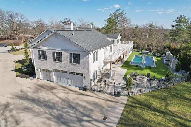 view of front facade featuring driveway, a front lawn, a patio, fence, and an attached garage