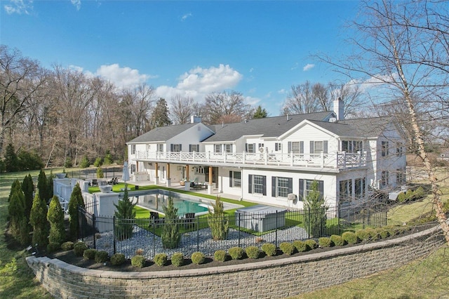 back of property with an outdoor living space, a balcony, a fenced backyard, and a patio area