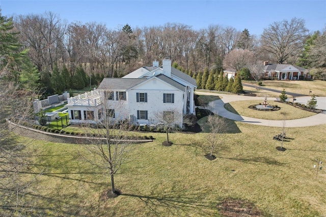 exterior space featuring driveway, a chimney, a yard, and fence