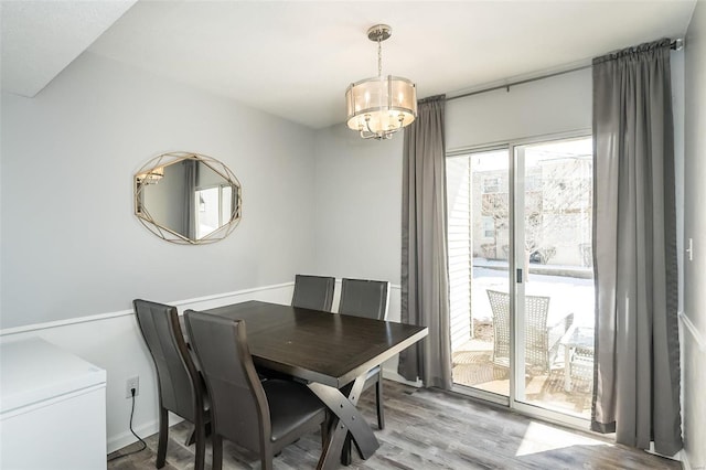 dining space featuring light wood-style floors and a chandelier