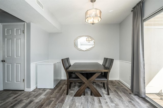 dining space featuring dark wood-type flooring, visible vents, and baseboards