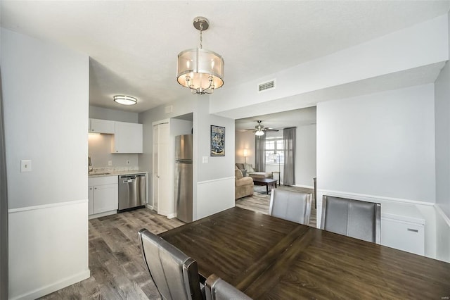 interior space featuring stainless steel appliances, white cabinets, light countertops, and hanging light fixtures