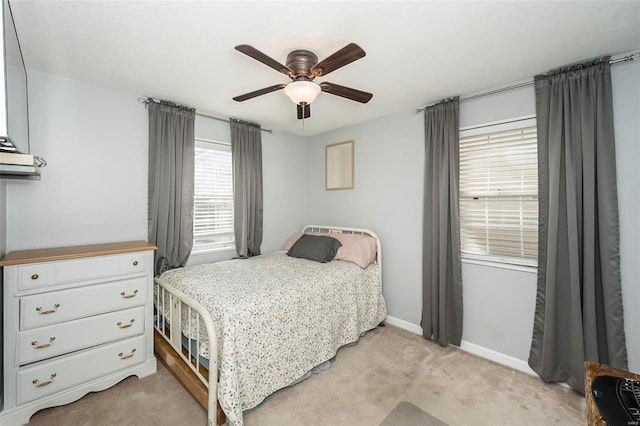 bedroom with ceiling fan, baseboards, and light colored carpet