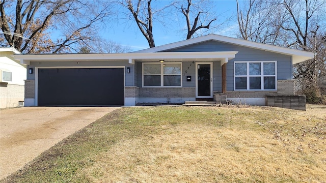 view of front of house featuring a garage, a front yard, brick siding, and driveway