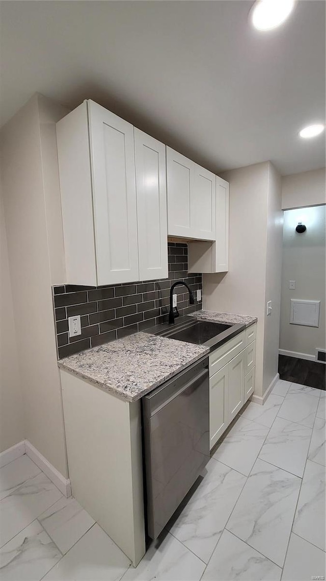 kitchen featuring a sink, white cabinetry, marble finish floor, stainless steel dishwasher, and tasteful backsplash