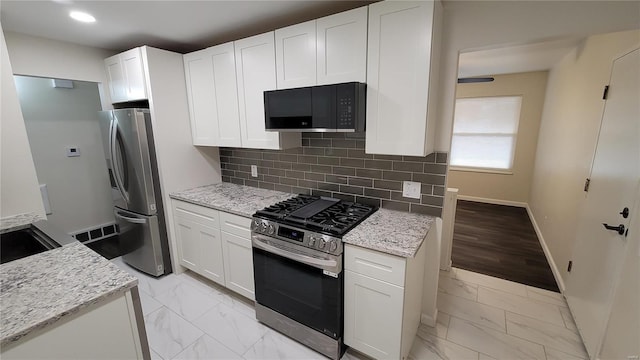 kitchen featuring marble finish floor, appliances with stainless steel finishes, and white cabinets