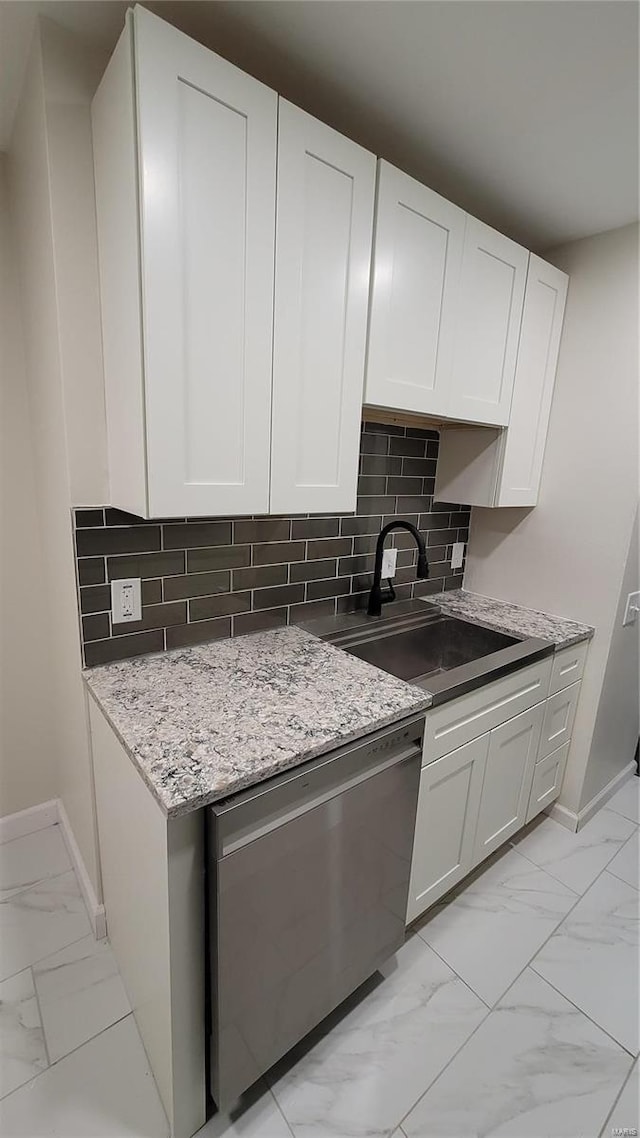 kitchen featuring dishwasher, marble finish floor, a sink, and white cabinets