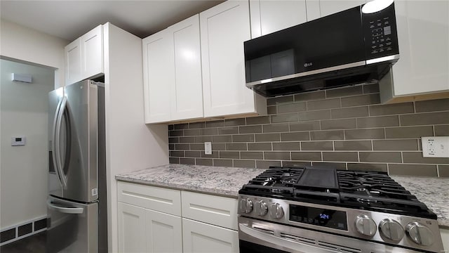 kitchen with visible vents, appliances with stainless steel finishes, white cabinetry, and decorative backsplash