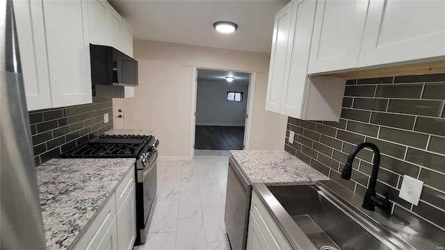 kitchen featuring marble finish floor, white cabinetry, a sink, and black gas range