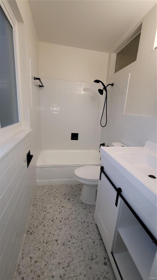 full bathroom featuring toilet, shower / bath combination, tile walls, and vanity