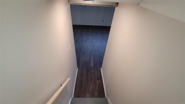 stairway featuring baseboards, vaulted ceiling, and wood finished floors