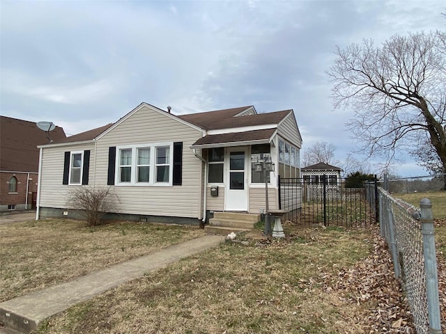 bungalow-style home with fence and a front lawn