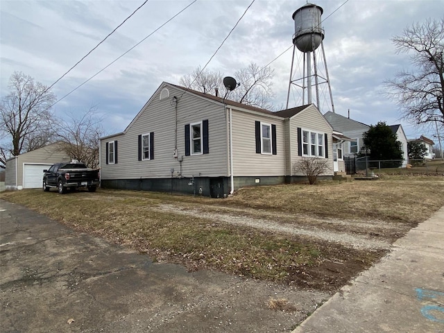 view of property exterior with a detached garage and an outbuilding