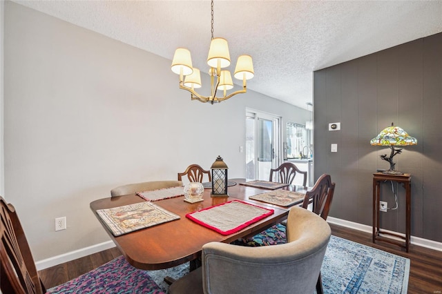 dining room with a textured ceiling, baseboards, a chandelier, and wood finished floors