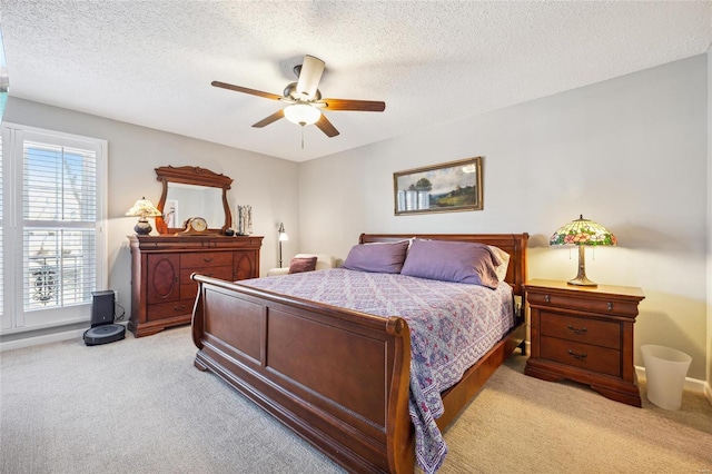 bedroom with a textured ceiling, a ceiling fan, and light colored carpet