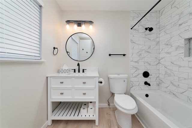 full bath with toilet, washtub / shower combination, vanity, wood finished floors, and baseboards