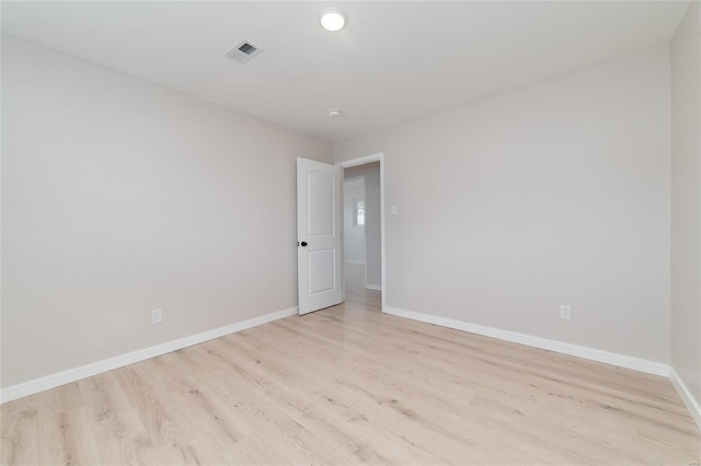 unfurnished room with visible vents, baseboards, and wood finished floors