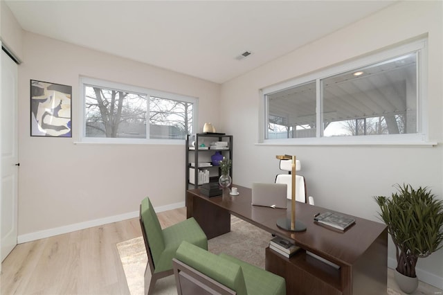 office area with plenty of natural light, visible vents, baseboards, and wood finished floors