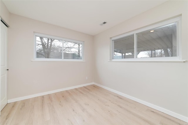 empty room with visible vents, baseboards, and wood finished floors