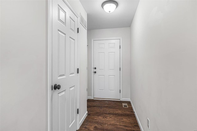 doorway with visible vents, baseboards, and dark wood finished floors